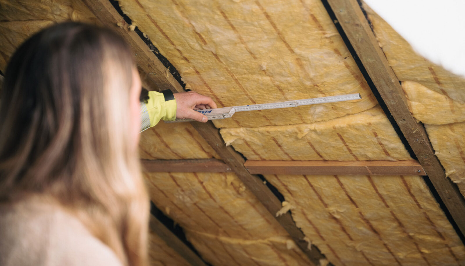 Architekt nimmt Maß vom Dachgeschoss für Planung der Dämmmaßnahmen