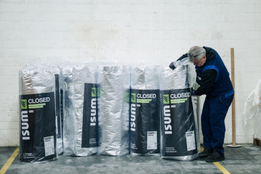 Mitarbeiter verpackt ISUM Closed Dämmfolie und stellt sie zu den bereits verpackten Folien.